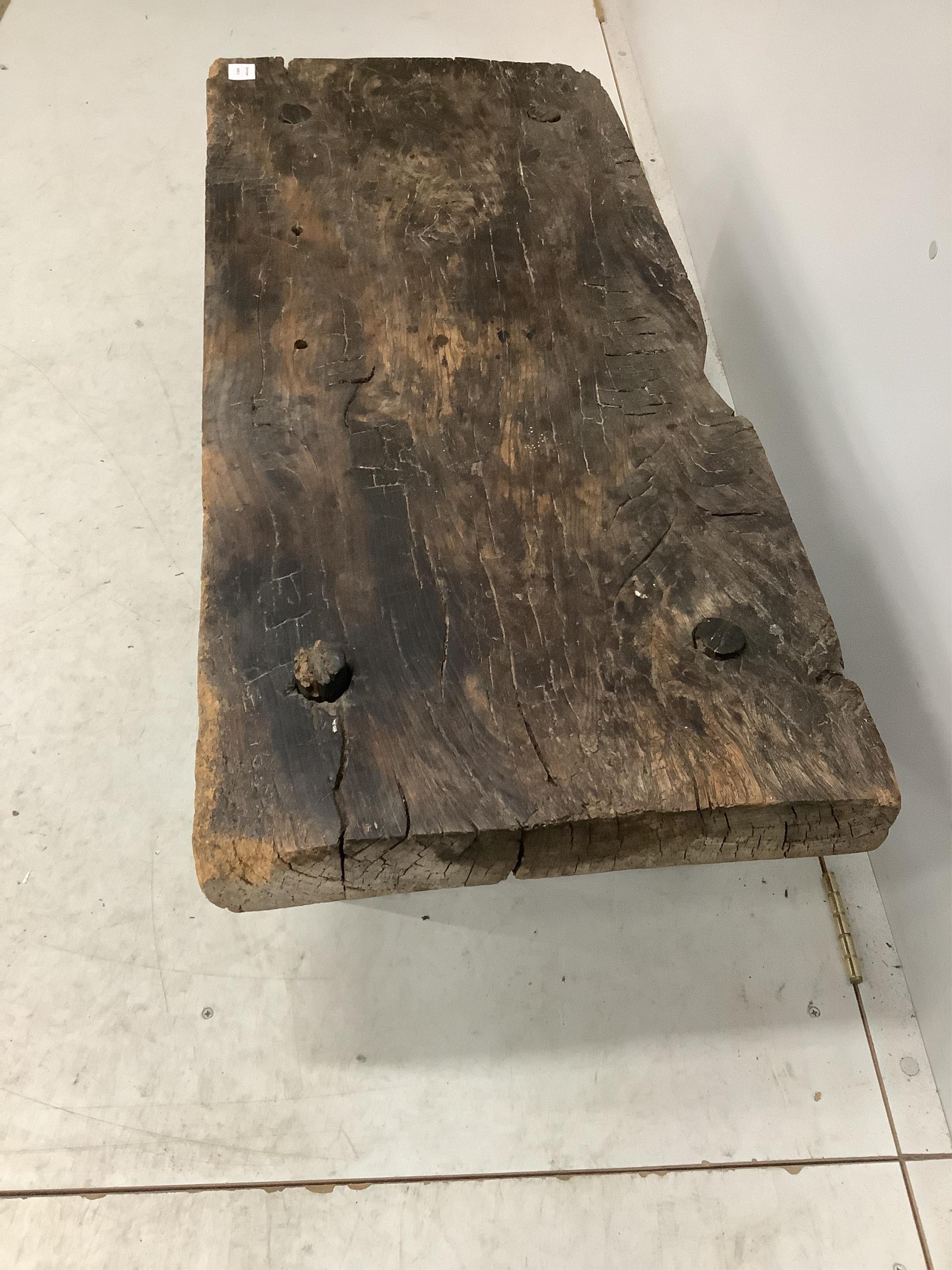 A Provincial rustic oak low table, on pegged supports, width 110cm, depth 50cm, height 33cm. Condition - poor to fair